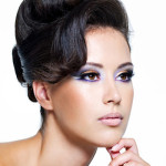 Beautiful face of a glamour woman with modern curly hairstyle and brightly makeup